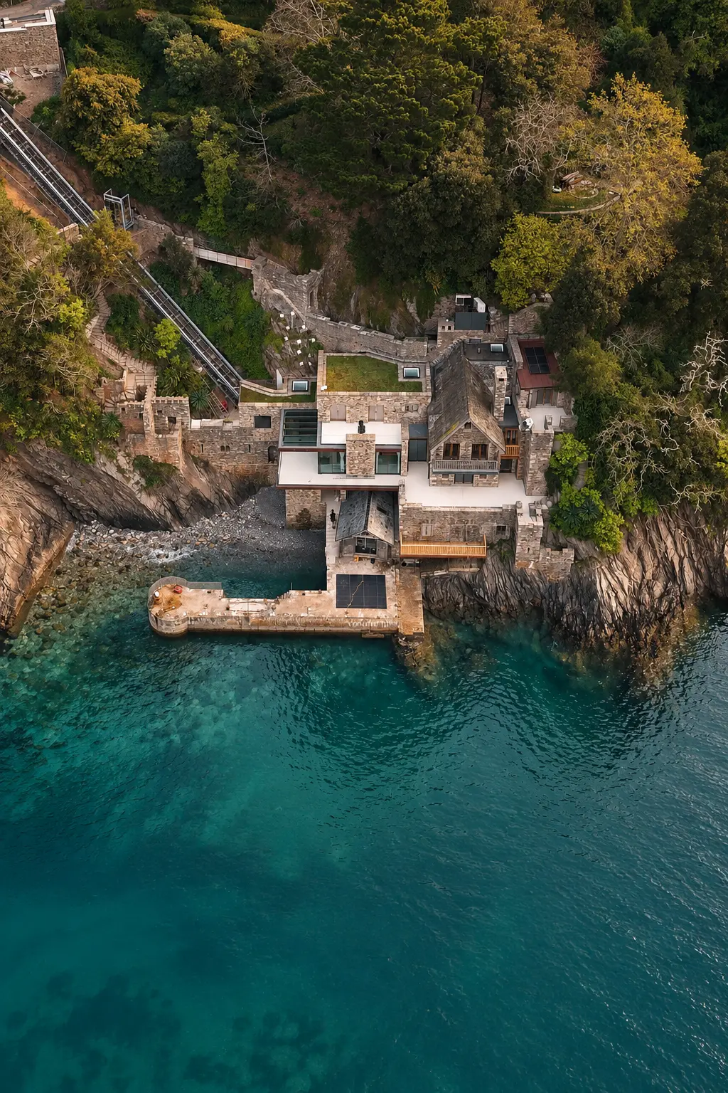 Dartmouth, Devon — A clifftop home above turquoise water, presented through its setting.